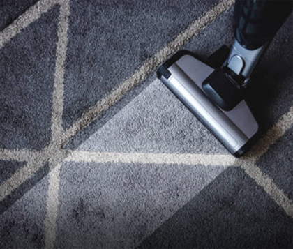 Professional carpet cleaning machine lifting dirt from a patterned carpet